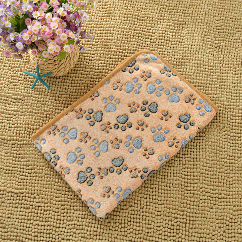 Beige bath mat with paw prints on a textured surface, next to a basket of flowers.