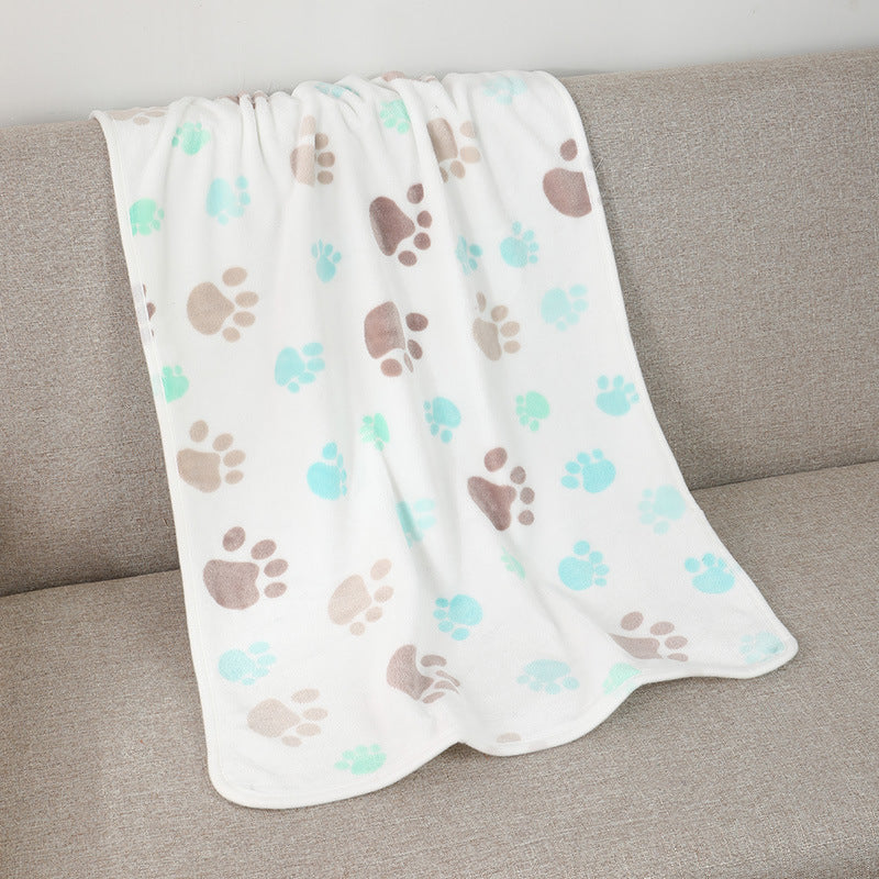 Blanket with paw prints on a gray couch