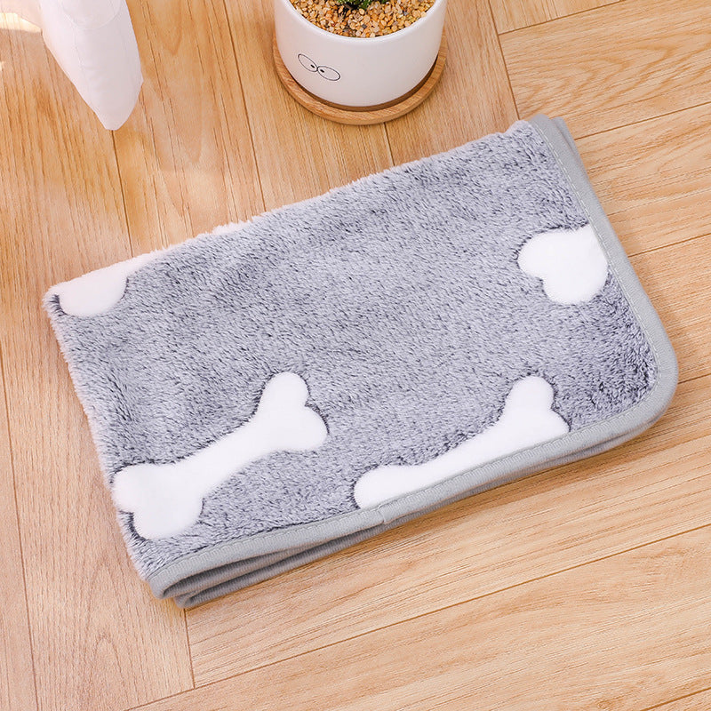 Gray pet mat with white bone designs on a wooden floor