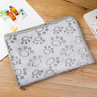 Gray towel with paw prints on a wooden surface