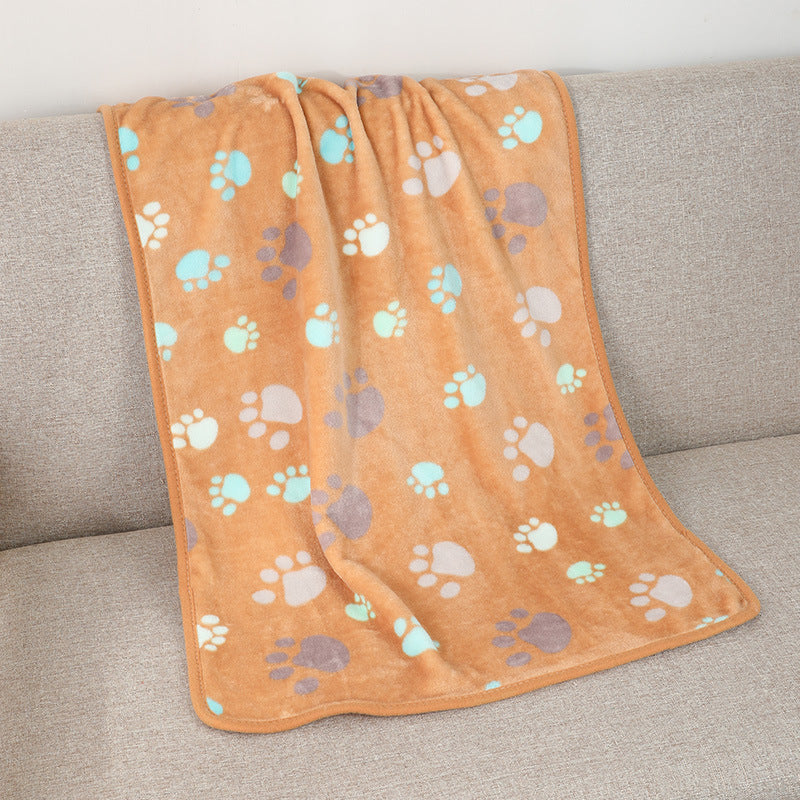 Orange blanket with paw prints on a gray couch