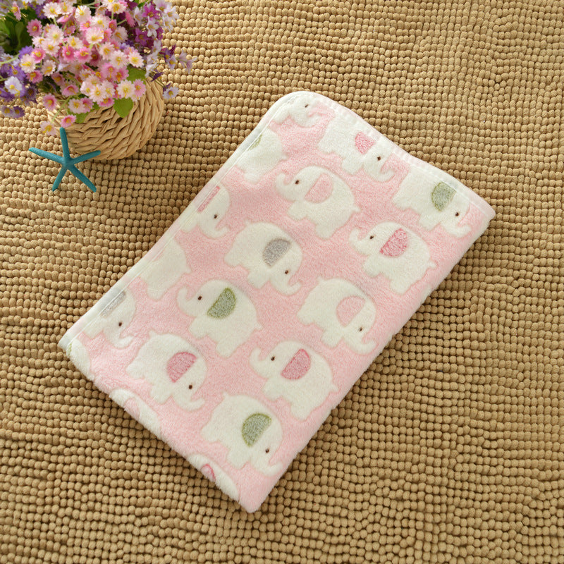 Pink blanket with elephant pattern on a textured surface with flowers in the background