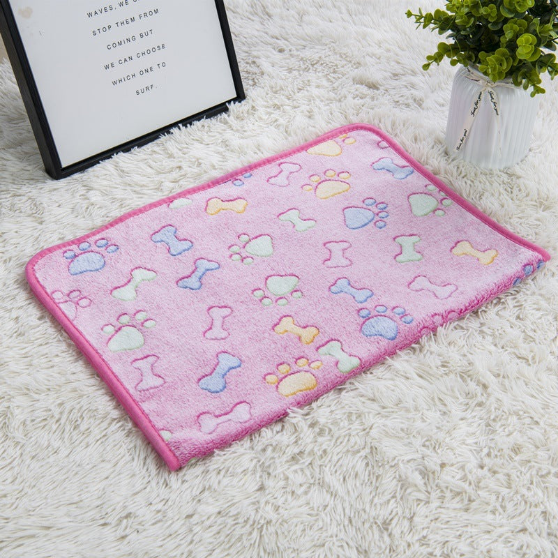 Pink mat with paw and bone patterns on a white surface