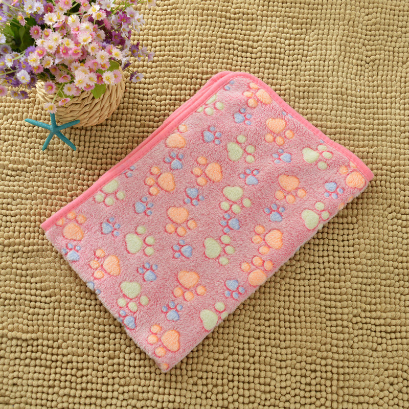 Pink towel with paw print pattern on a textured surface
