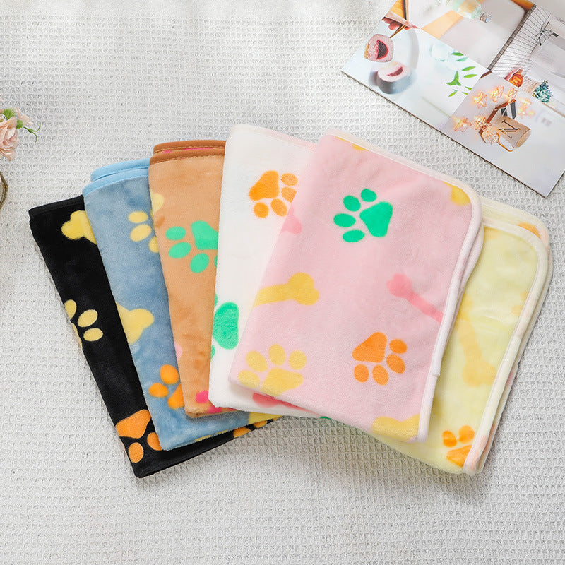 Set of colorful pet blankets with paw prints on a textured surface
