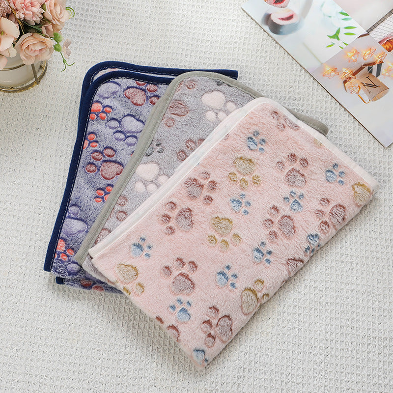 Three patterned pouches on a textured surface with flowers and a magazine in the background.