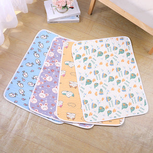Four baby play mats with cartoon patterns on a wooden floor.