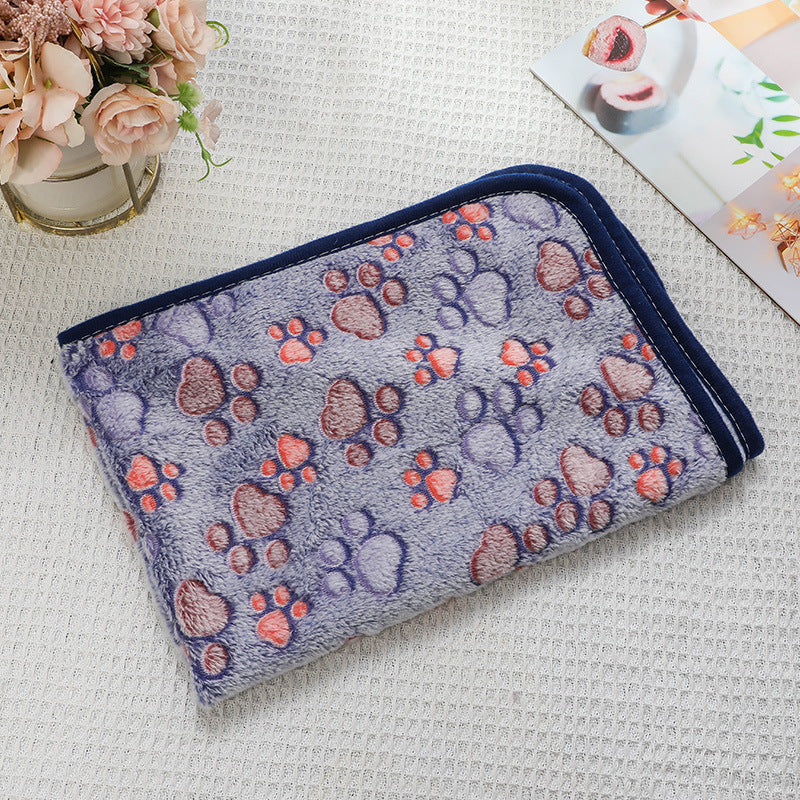 Folded towel with paw print pattern on a textured surface